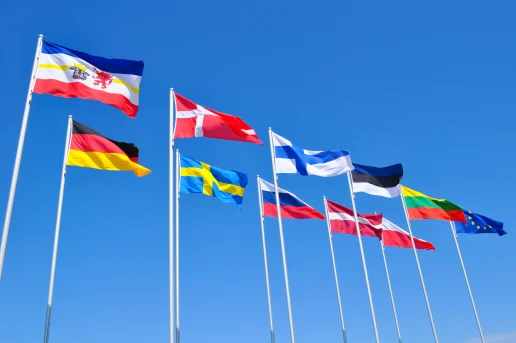 MV-Ostseekooperation Flaggen Die Flaggen von Mecklenburg-Vorpommern, Deutschland, den Ostseeanrainerstaaten und der EU wehen nebeneinander an hohen Fahnenmasten vor einem strahlend blauen Himmel.